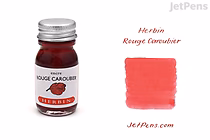 A 10 ml bottle of Herbin Rouge Caroubier (Carob Red) ink with a silver cap. Next to the bottle is a swatch of the ink showing a rich red color. The text "Herbin Rouge Caroubier" and "JetPens.com" are displayed near the swatch.