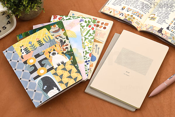 A collection of Midori Yuru Log Notebooks in B6 size with MD cream paper and 5 mm dotted grids, featuring covers with forest animal illustrations. One notebook is open, showing handwritten notes and drawings.