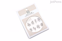 A package of clear stamps featuring various small wildflower designs arranged in a circular pattern. The packaging is white with orange diagonal stripes at the top and bottom, and includes text and branding.