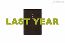 Cover of a Hobonichi Techo Book Only planner in A6 size, English edition, with a black textured surface and gold Japanese characters embossed in the center. The planner is for January 2025 start.