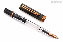 A TWSBI ECO Serpentine fountain pen with a transparent barrel and bronze-colored cap and nib, shown uncapped with the cap placed beside the pen. The nib is fine-point.