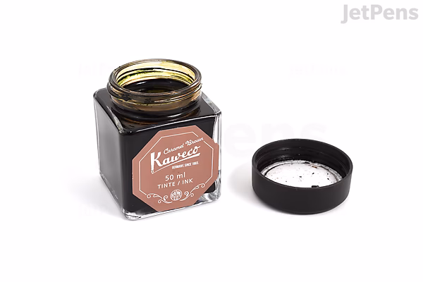 Open square glass bottle of Kaweco Caramel Brown fountain pen ink with black screw-on lid placed beside it on a white surface. The label on the bottle is brown with white text.