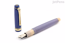 A Sailor Pro Gear Slim fountain pen in a limited edition "Dreamy Hour" design, featuring a lavender barrel, cream-colored grip section, and a gold-trimmed cap with a clip, displayed uncapped with the 14k extra fine nib visible.