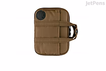 Light brown Hobonichi Techo A6 planner cover with rounded corners, zip closure, exterior pockets, small handle and pen loop.