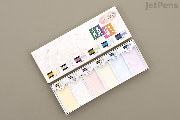 Open Boku-Undo Gansai Aurora 6-color watercolor set showing six pastel pans in a white palette, mixing wells and color swatches on the lid, displayed on a gray background.