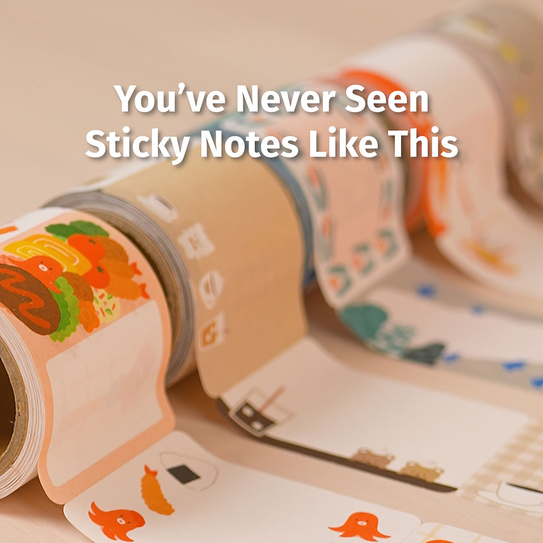 Rolls of decorative sticky-note tape with colorful illustrated designs (animals, food, plants) unrolled on a tabletop.